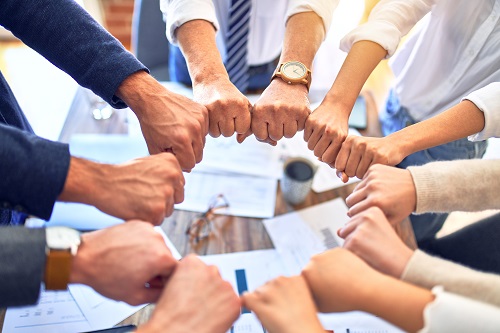 Group,Of,Business,Workers,Standing,Bumping,Fists,At,The,Office